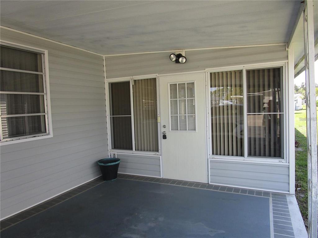 A single-story mobile home at night with illuminated landscaping and a gravel front yard — 47 KONO CIRCLE, LEESBURG, FL