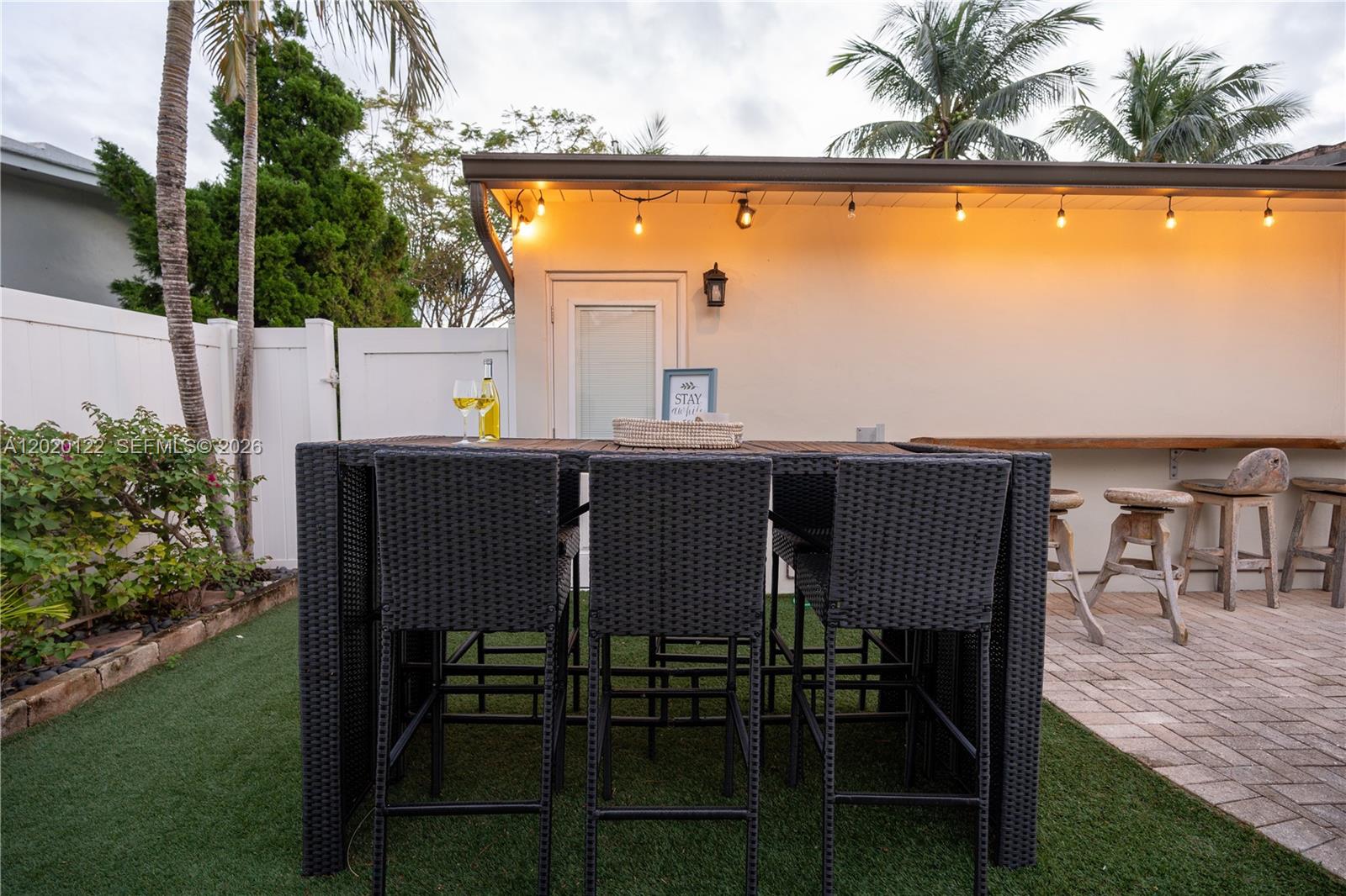 An outdoor patio features a high-top dining set on artificial turf beside a paved bar area — 1311 NE 26th Ter, Pompano Beach FL 33062, POMPANO BEACH, FL