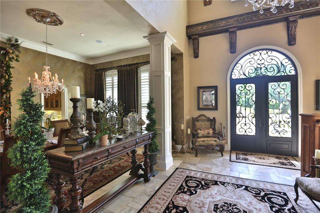 An elegant foyer features a stone floor, arched double doors, and a formal dining area — 15305 NW HWY 320, MICANOPY, FL