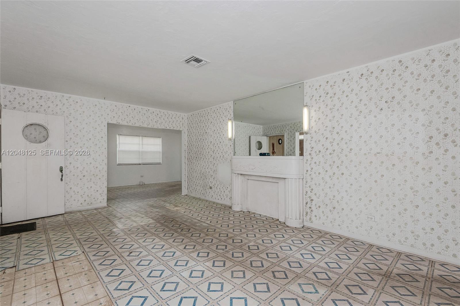 A living room features patterned wallpaper, a tiled floor, and a decorative fireplace with mirrors — 245 NE 48th St, Miami FL 33137, MIAMI, FL