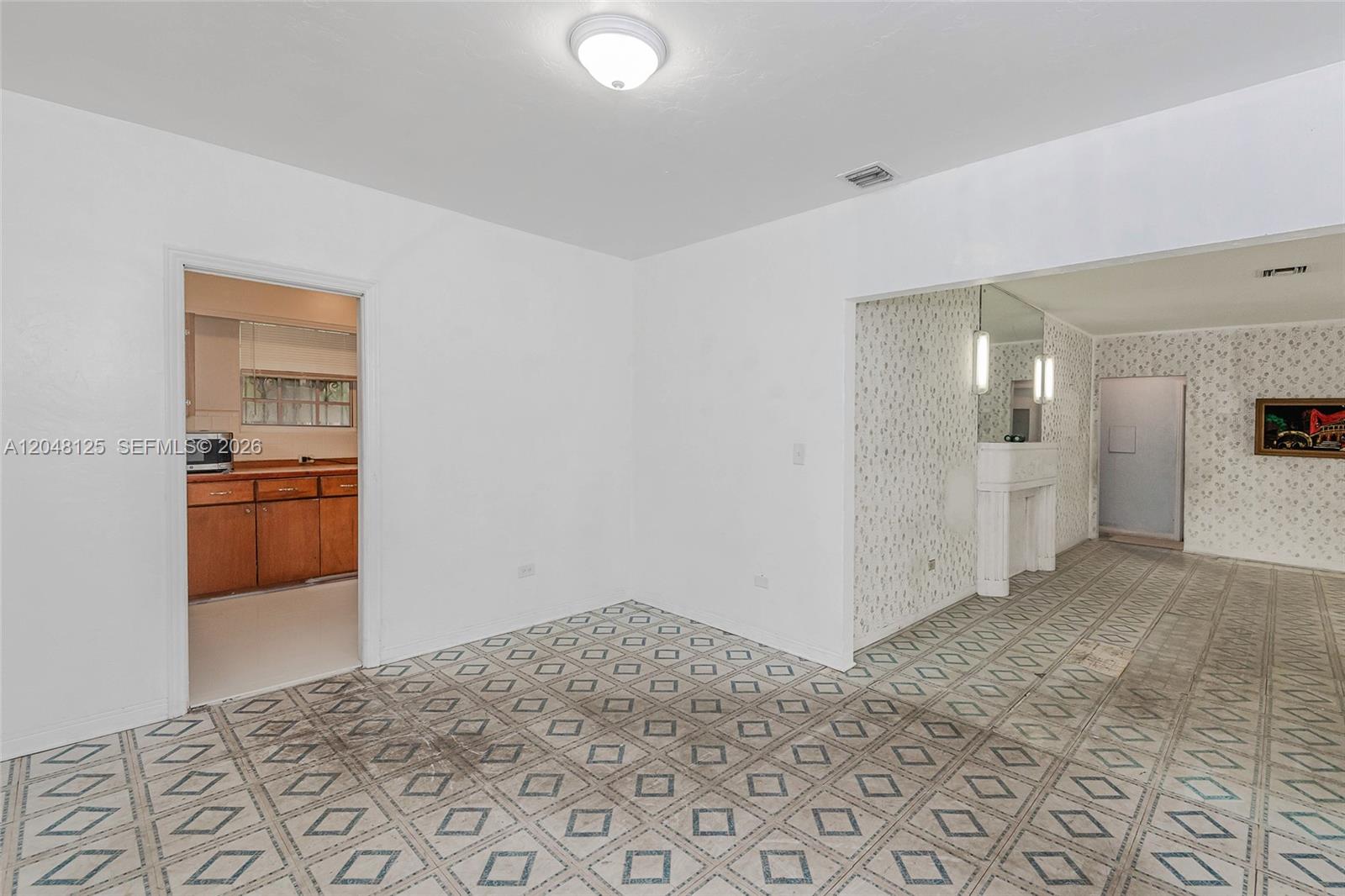 A dining area with patterned tile flooring connects to a kitchen and a living room — 245 NE 48th St, Miami FL 33137, MIAMI, FL