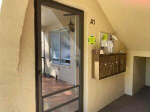 A glass-paned door leads to a screened porch next to a row of metal mailboxes — 446 Pine Glen Lane # 1, FL 33463, FL