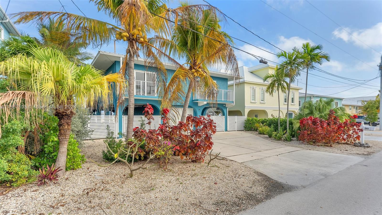 A blue two-story house with a palm tree in the front yard and a driveway — 441 La Fitte Rd # 0, Torch Key FL 33042, TORCH KEY, FL