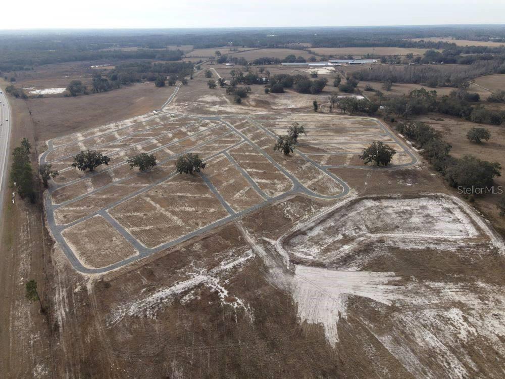 An aerial view shows a cleared residential subdivision with paved roads and scattered oak trees — 3773 72ND STREET, LIVE OAK, FL