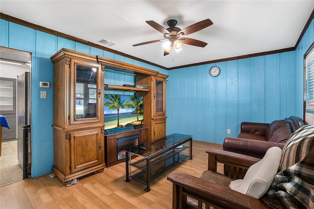 A living room features blue wood-paneled walls, a large wooden entertainment center, and leather furniture — VERO BEACH, FL