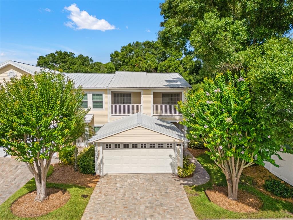 A two-story house with a metal roof, a two-car garage, and two upper-level balconies — 902 WOODBRIDGE COURT, SAFETY HARBOR, FL