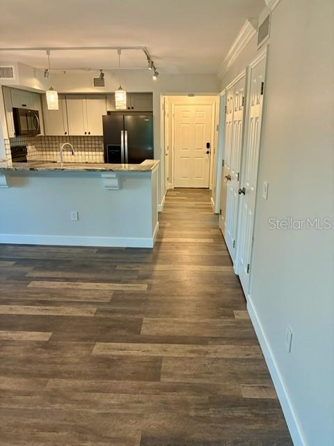A kitchen with a breakfast bar, stainless steel appliances, and wood-look flooring — 2400 FEATHER SOUND DRIVE UNIT 1031, CLEARWATER, FL