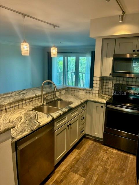 A kitchen features granite countertops, stainless steel appliances, and pendant lighting over the sink area — 2400 FEATHER SOUND DRIVE UNIT 1031, CLEARWATER, FL