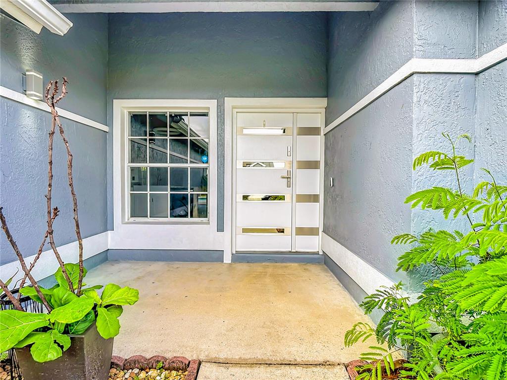 A covered entryway features a white front door with horizontal glass panels and a window — 3247 TIMUCUA CIRCLE, ORLANDO, FL