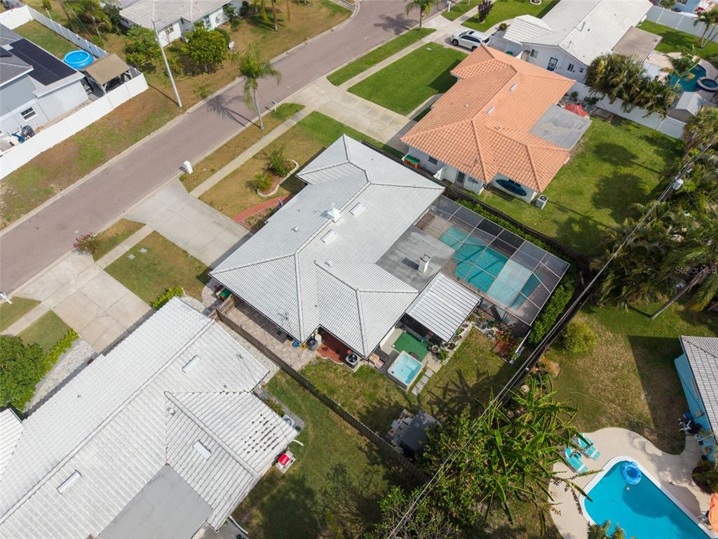 An aerial view shows a house with a pool, screened lanai, and metal roof — 5676 WILLIAMS BOULEVARD, SEMINOLE, FL