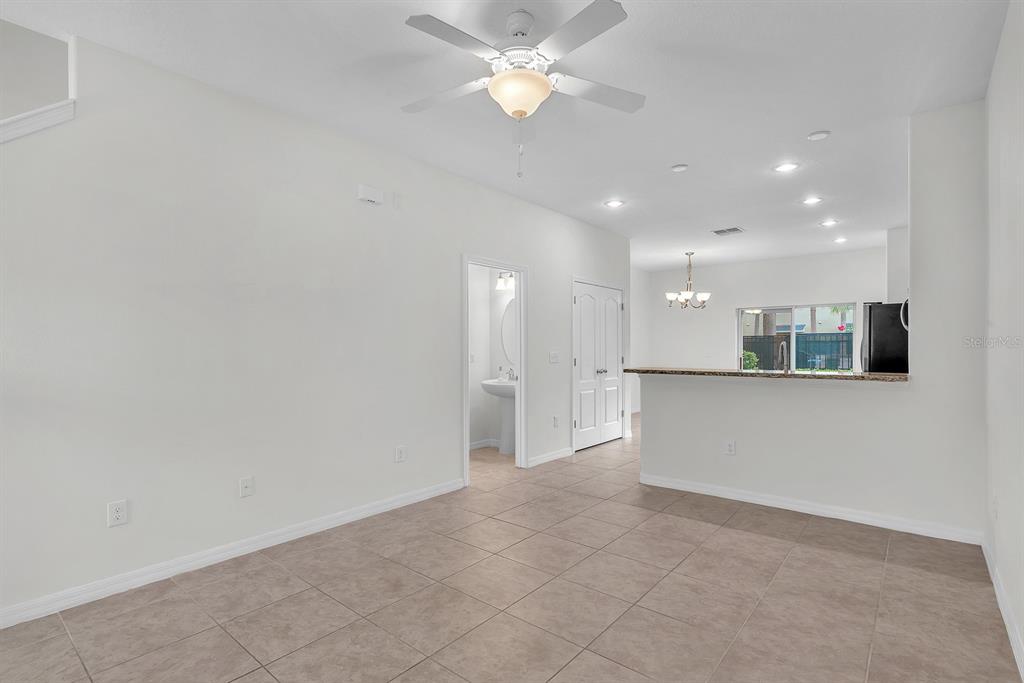 An open-concept living area features tile flooring, a ceiling fan, and an adjacent kitchen — 2719 LANTERN HILL AVENUE, BRANDON, FL