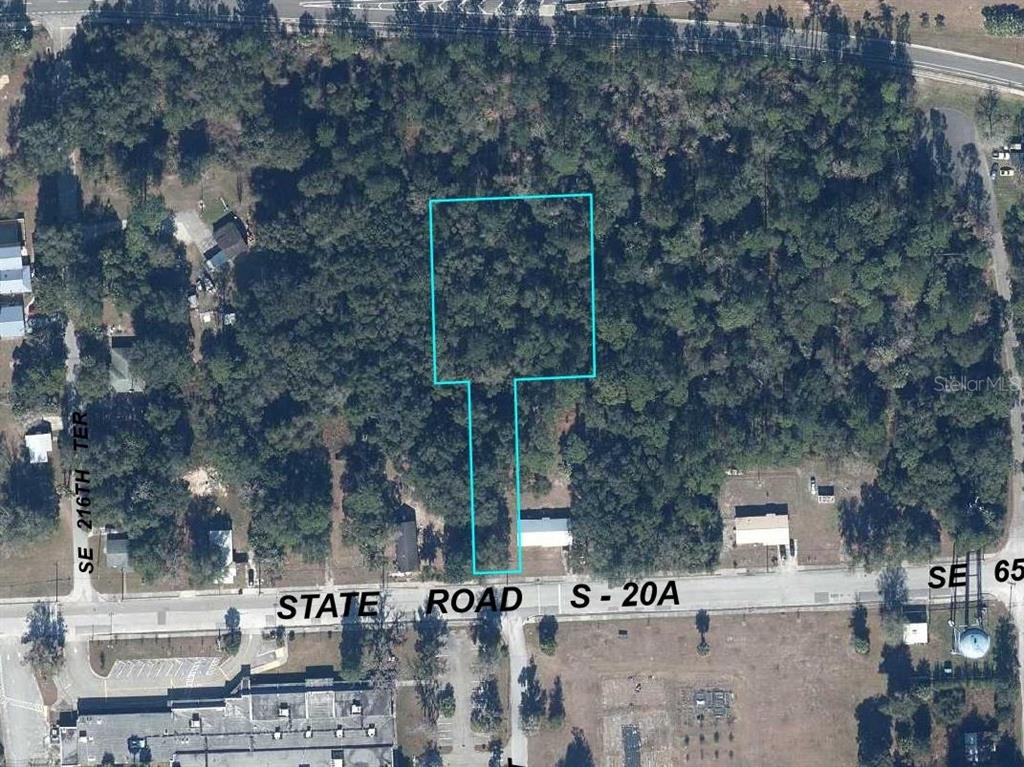 An aerial view shows a flag-shaped lot outlined in blue along a paved road — SE 65TH AVENUE, HAWTHORNE, FL