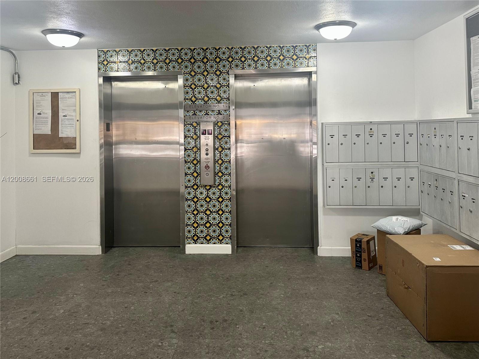 An elevator lobby features two stainless steel doors, patterned tile accents, and wall-mounted mailboxes — 1340 Lincoln Rd # 400, Miami Beach FL 33139, MIAMI BEACH, FL