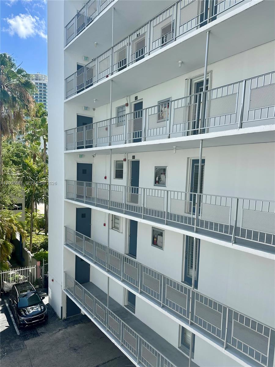 This exterior view shows the side of a multi-story apartment building with open-air walkways — 1340 Lincoln Rd # 400, Miami Beach FL 33139, MIAMI BEACH, FL