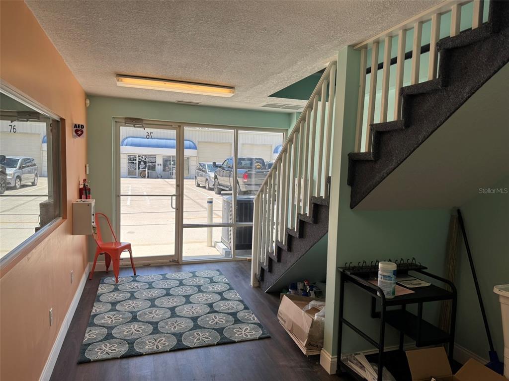 An interior view of an entryway featuring a staircase, a patterned rug, and glass doors — 2323 N STATE STREET UNIT 76, BUNNELL, FL