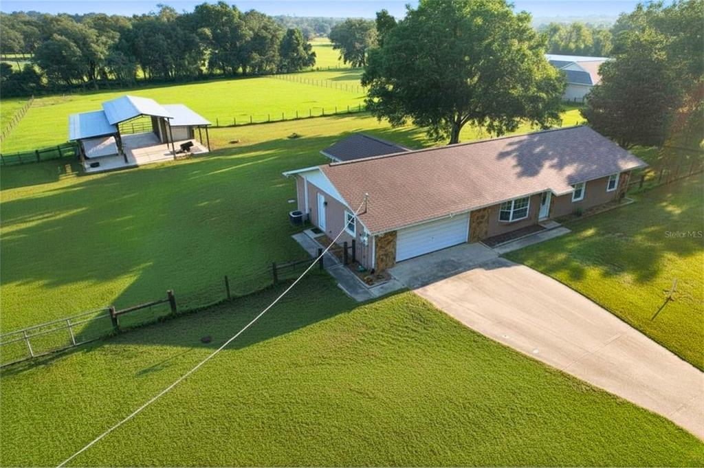 An aerial view shows a single-story house with a garage and a separate detached barn — 16520 SPRING VALLEY ROAD, DADE CITY, FL