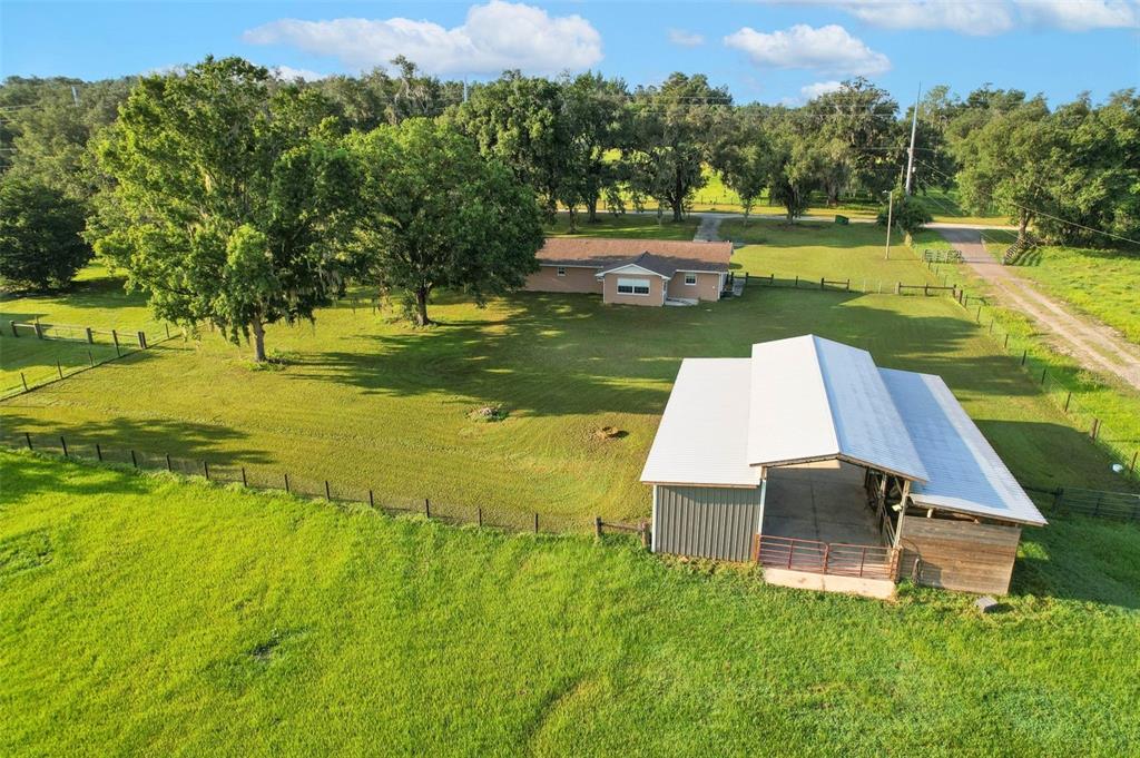An aerial view shows a house and a barn on a large, fenced grassy lot — 16520 SPRING VALLEY ROAD, DADE CITY, FL