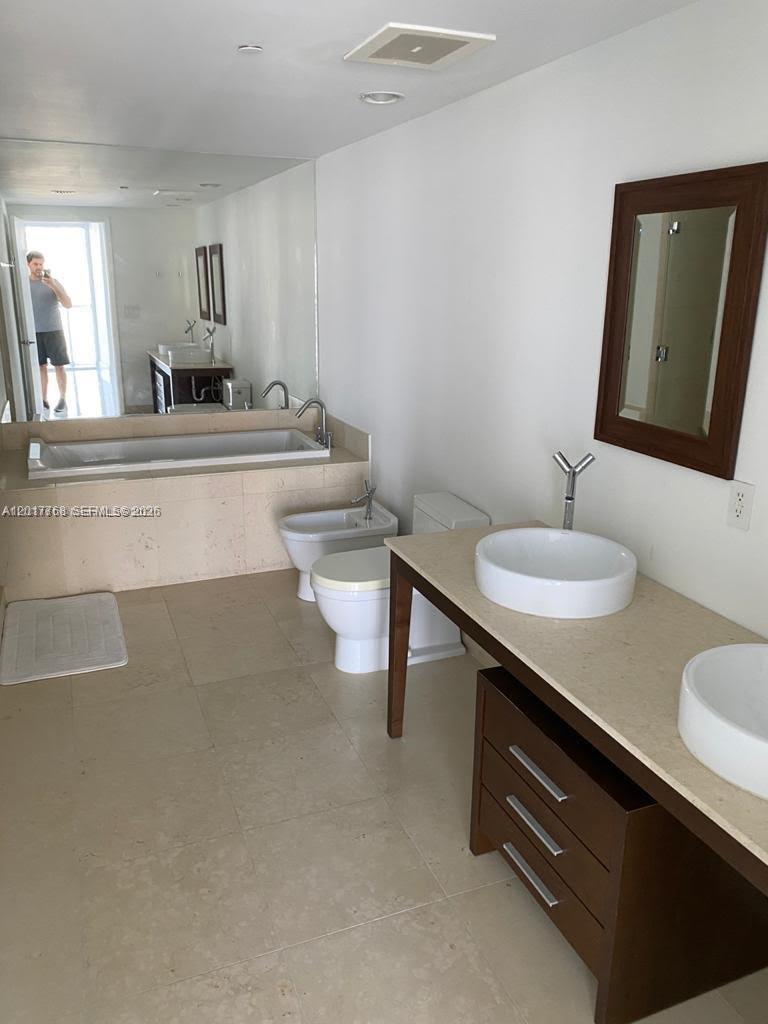 A bathroom features a double vanity with vessel sinks, a soaking tub, and a bidet — 495 Brickell Ave # 2902, Miami FL 33131, MIAMI, FL