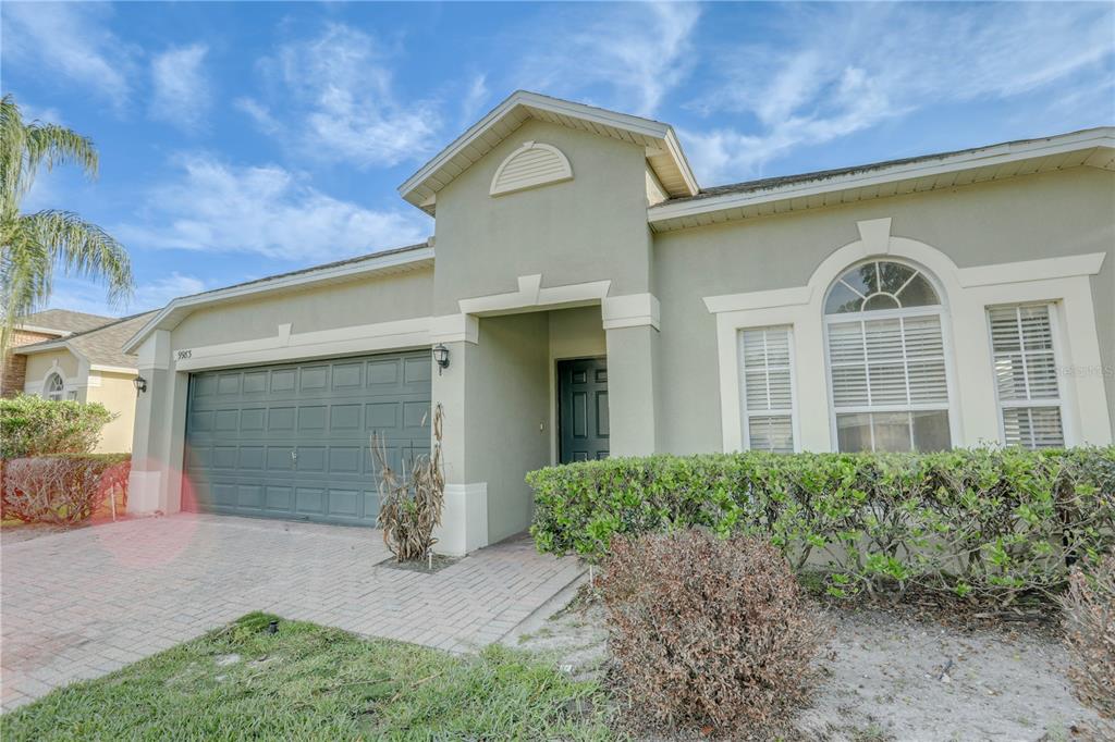 A single-story house with a green stucco exterior, a two-car garage, and a front entrance — 9983 BRODBECK BOULEVARD, ORLANDO, FL