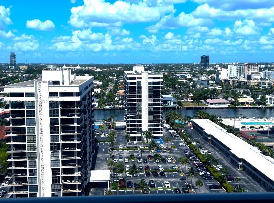 An aerial view shows a swimming pool deck with blue umbrellas beside a sandy beach — 2030 S Ocean Dr # 1802, Hallandale Beach FL 33009, HALLANDALE BEACH, FL