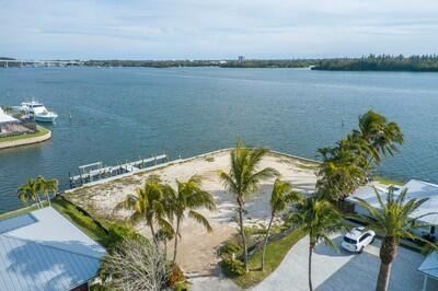An aerial view of a vacant waterfront lot with palm trees and a private dock — VERO BEACH, FL