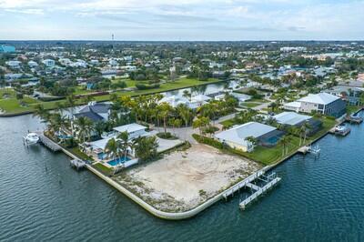 An aerial view shows a vacant waterfront lot surrounded by houses and boat docks — VERO BEACH, FL