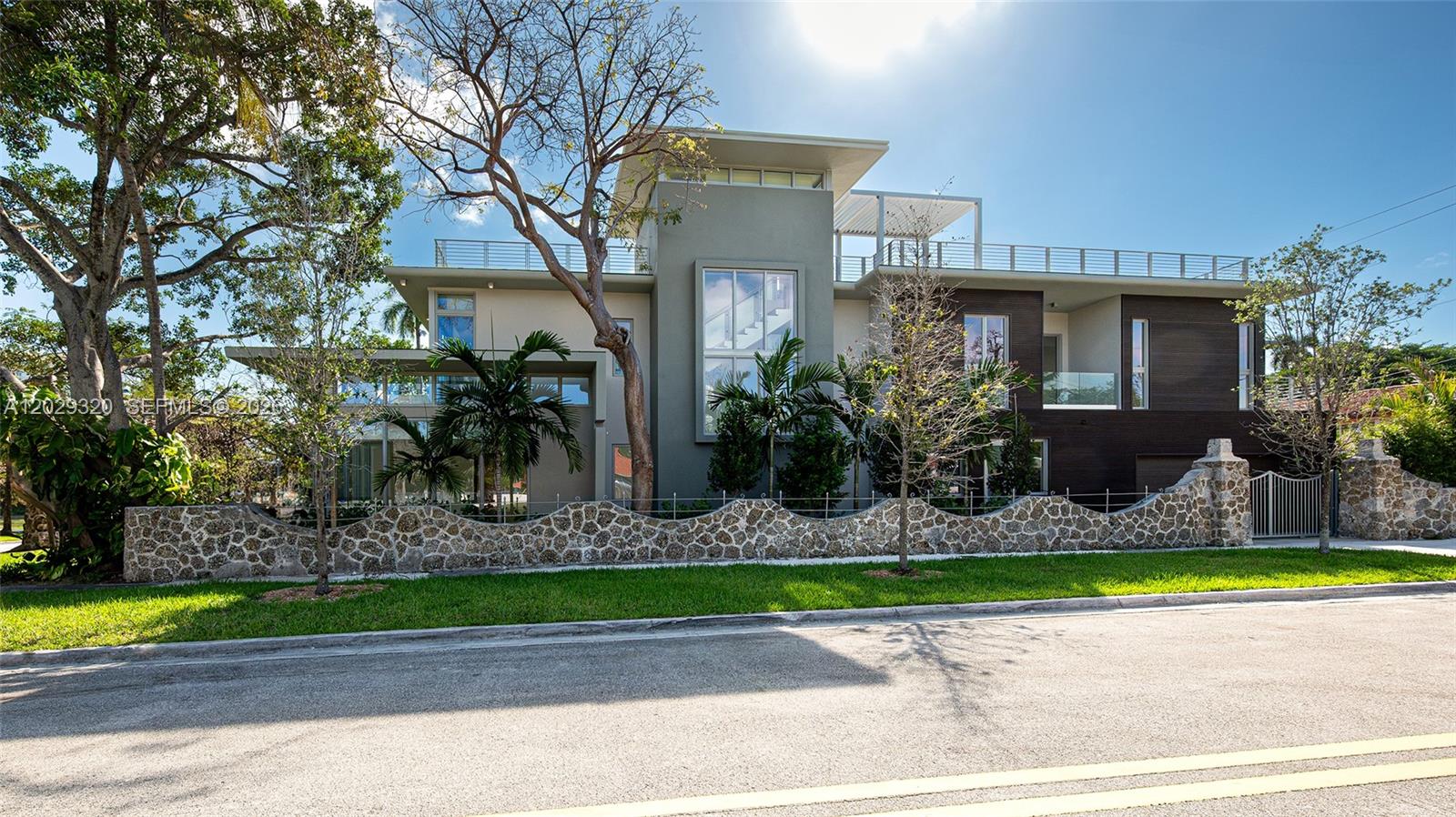 A modern two-story house features a stone wall, flat roof, and large glass windows — 2100 S Miami Ave, Miami FL 33129, MIAMI, FL