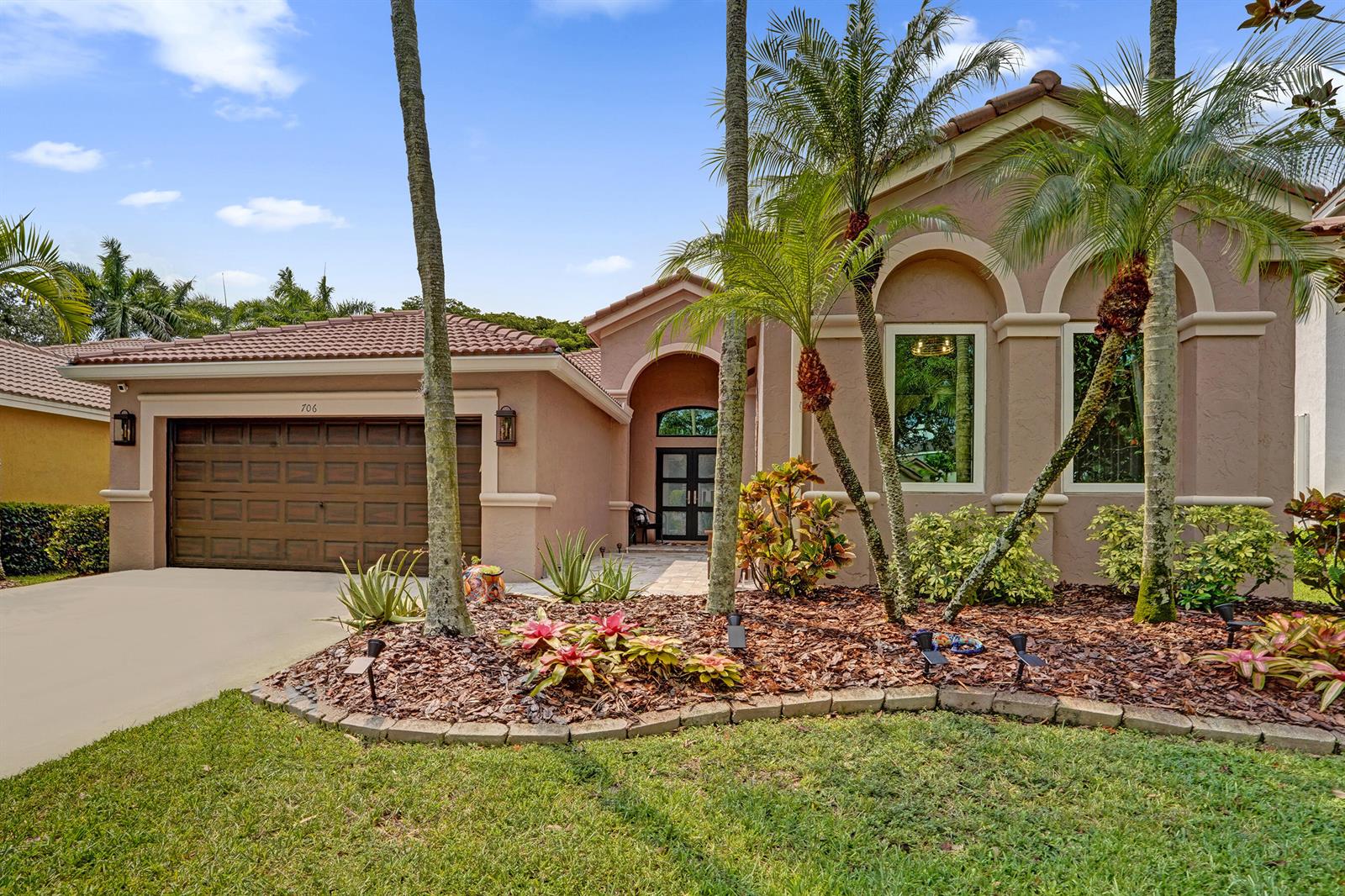 A single-story stucco house with a tile roof, two-car garage, and landscaped front yard — 706 Tulip Circle, Weston FL 33327, WESTON, FL