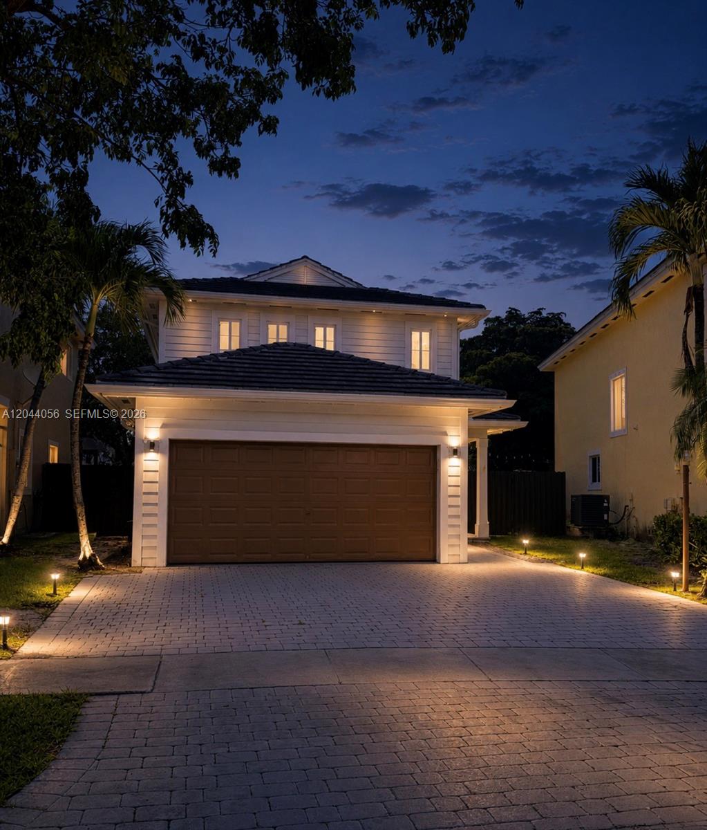 A two-story house with a brown garage door and a paved driveway at twilight — 363 NE 35th Ter, Homestead FL 33033, HOMESTEAD, FL
