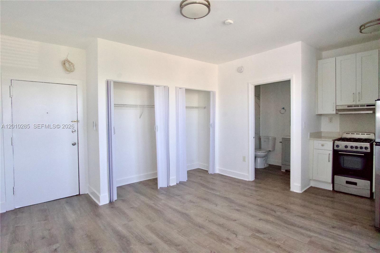 This studio apartment features light wood-look flooring, white walls, two closets, and a small kitchen — 501 SW 6th Ct # 322, Miami FL 33130, MIAMI, FL