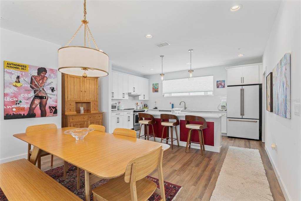 A dining area with a wooden table and hutch opens into a kitchen with island seating — 2621 1ST AVENUE N UNIT 19, ST PETERSBURG, FL