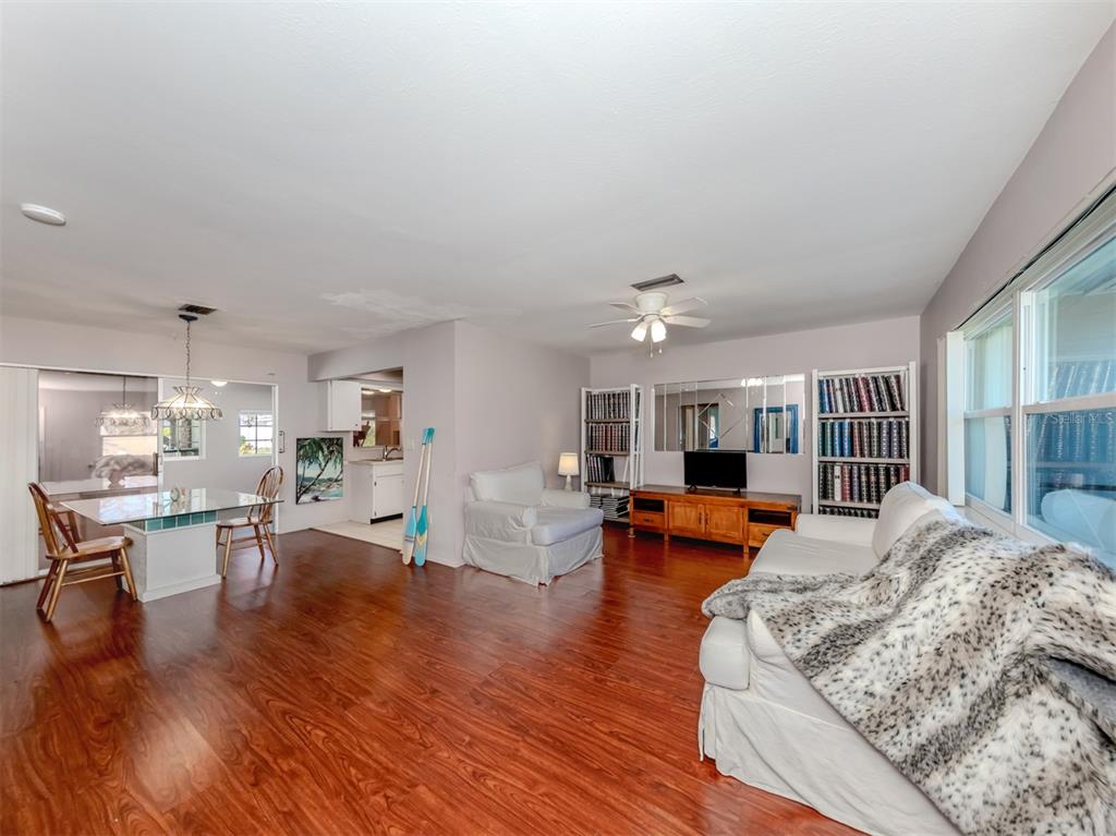 A living and dining area with wood flooring, white walls, and a ceiling fan — 424 CENTER ROAD, VENICE, FL