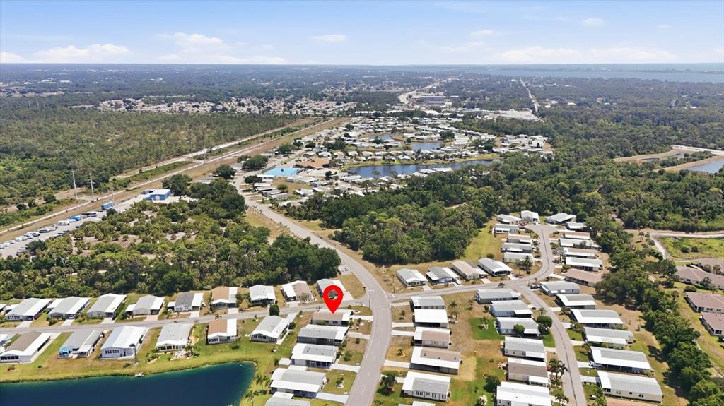 An aerial view shows a residential community with a red location pin on a house — 803 TANGERINE WOODS BOULEVARD, ENGLEWOOD, FL