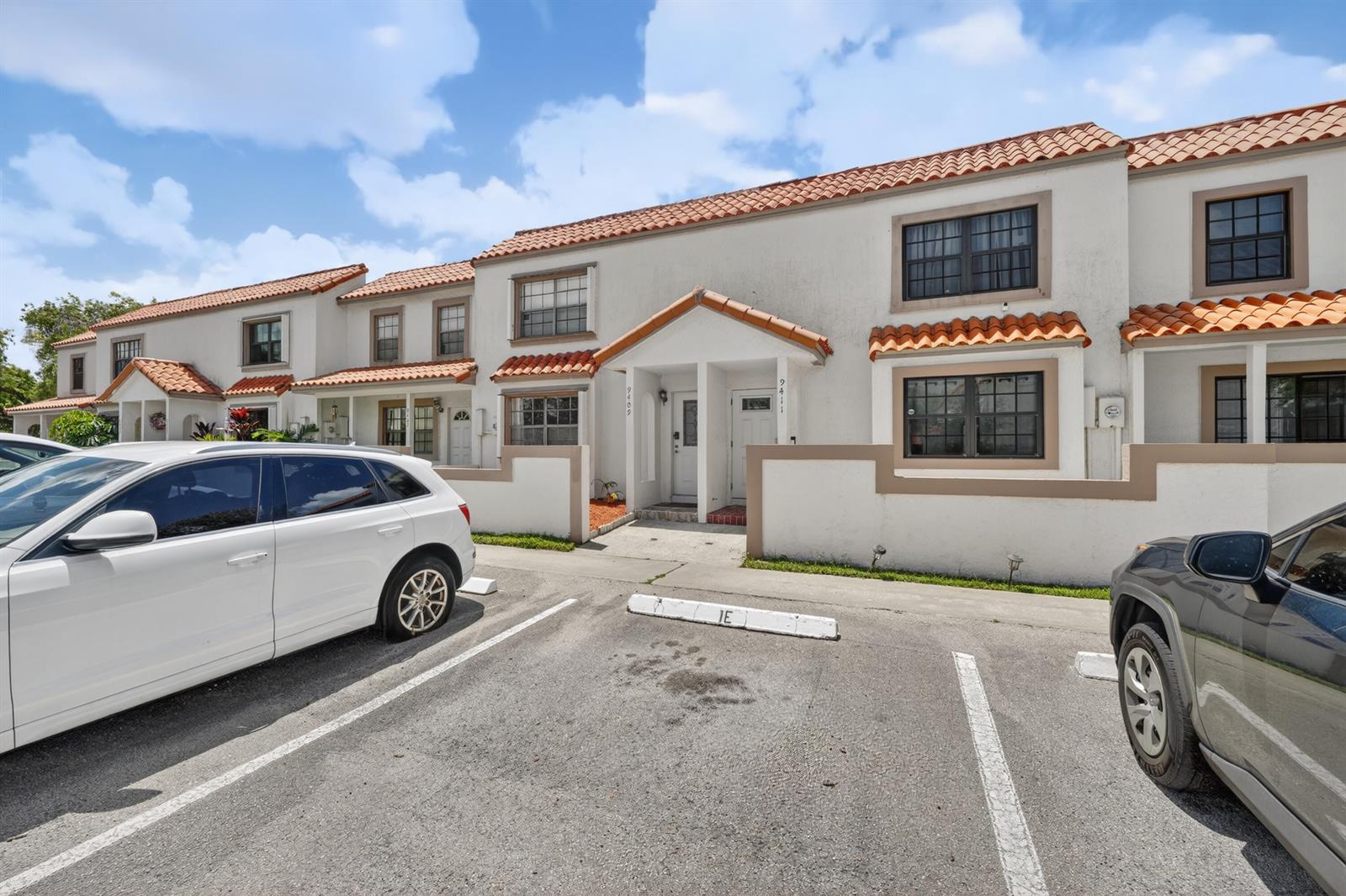 A row of two-story townhomes with white stucco walls and terracotta tile roofs — 9409 NW 42nd Street, Sunrise FL 33351, SUNRISE, FL