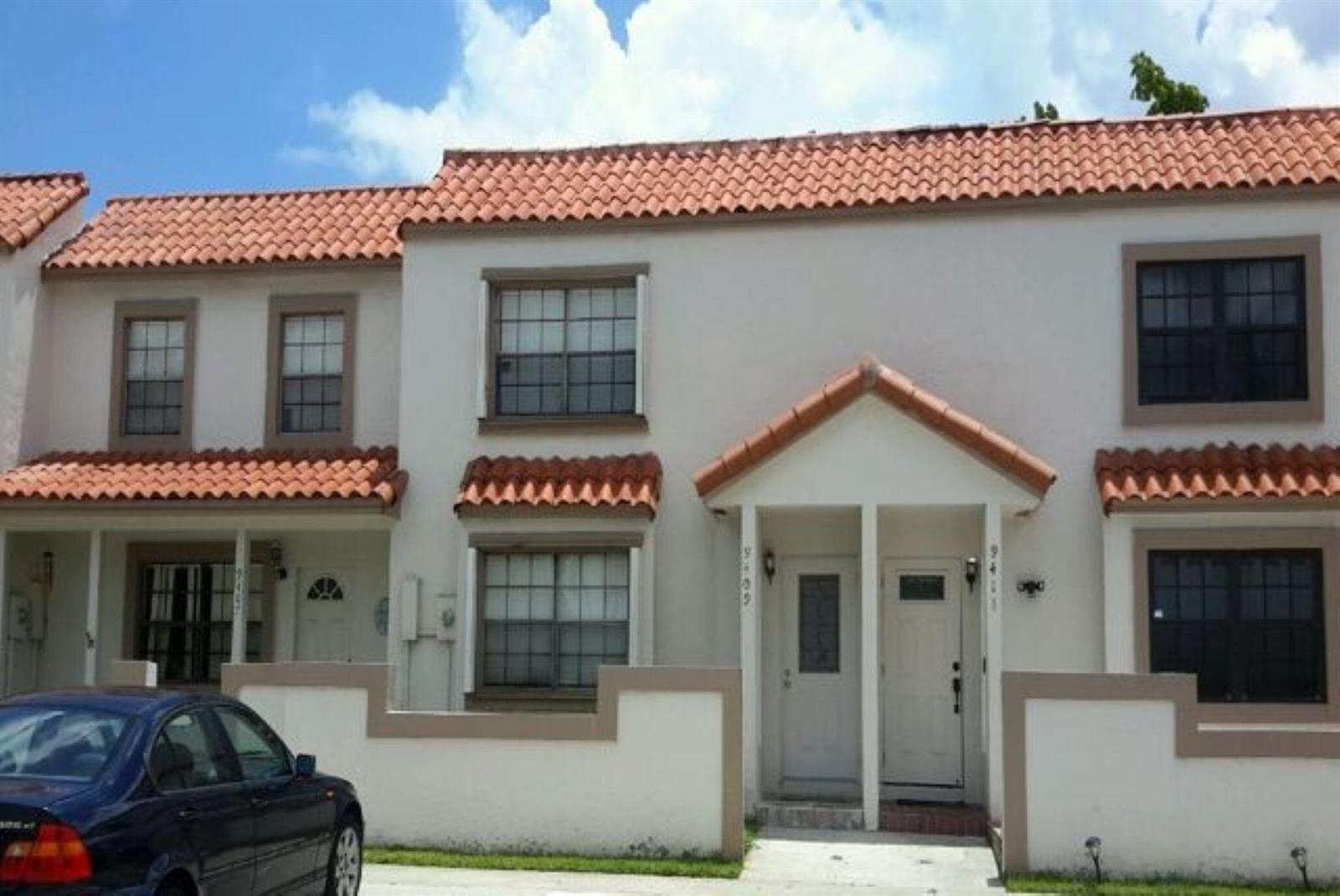 A row of two-story townhouses with white stucco walls and terracotta-tiled roofs — 9409 NW 42nd Street, Sunrise FL 33351, SUNRISE, FL
