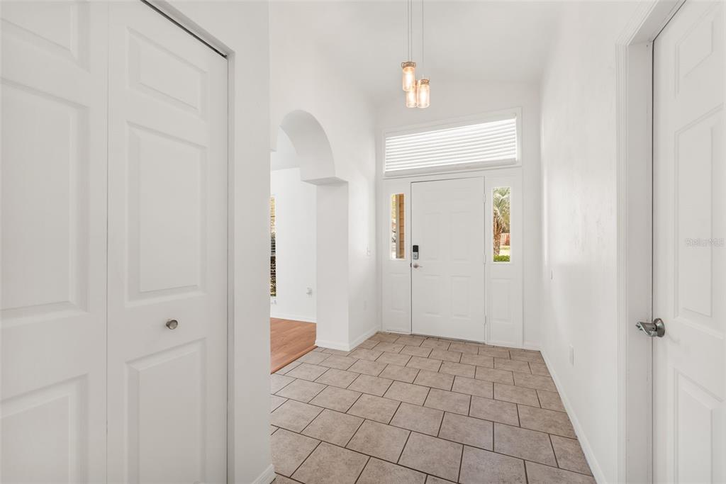 An entryway with tile flooring, a white front door, and a white arched doorway — 6220 SW 81ST STREET, GAINESVILLE, FL