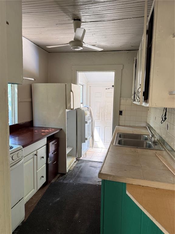 A narrow kitchen features a white refrigerator, a double-basin sink, and a ceiling fan — 2007 43RD STREET S, GULFPORT, FL