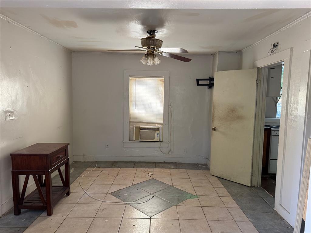 A room with tiled flooring, a ceiling fan, a window air conditioner, and a wooden table — 2007 43RD STREET S, GULFPORT, FL