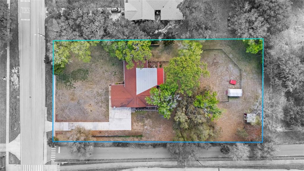 An aerial view shows a house with a red roof situated on a large lot — 3065 KNOX MC RAE DRIVE, TITUSVILLE, FL