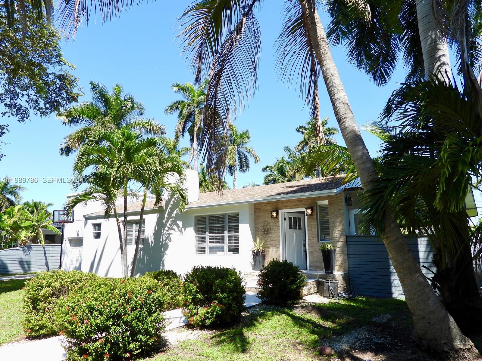 A single-story house with a white facade, stone entryway, and palm trees in the yard — 715 Hollywood Blvd, Hollywood FL 33019, HOLLYWOOD, FL