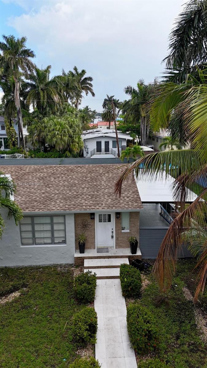 An elevated view of a single-story house with a shingled roof and palm trees — 715 Hollywood Blvd, Hollywood FL 33019, HOLLYWOOD, FL