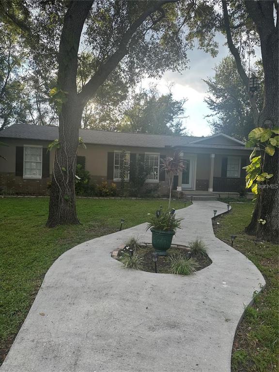 A single-story house with a curved concrete walkway leading to the front porch — 10520 HENDERSON ROAD, TAMPA, FL