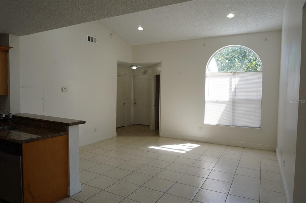 An open living area features tile flooring, a vaulted ceiling, and a large arched window — 2584 GRASSY POINT DRIVE UNIT 204, LAKE MARY, FL
