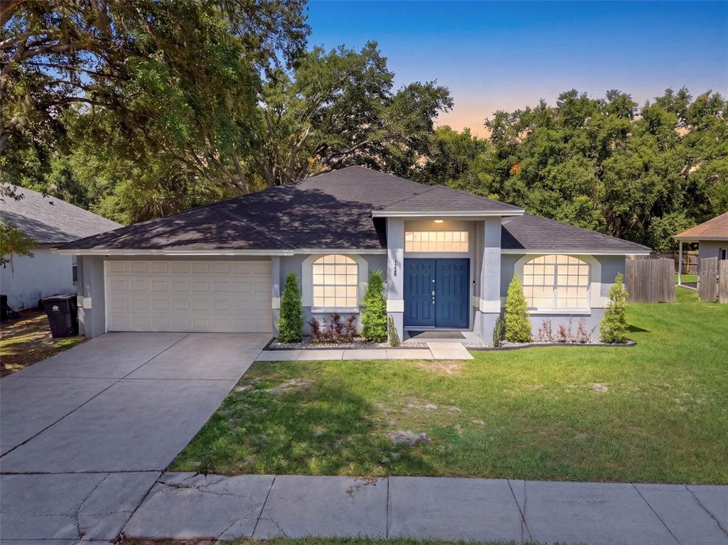 A single-story house with a gray exterior, blue double front doors, and a concrete driveway — 1328 GANGPLANK DRIVE, VALRICO, FL