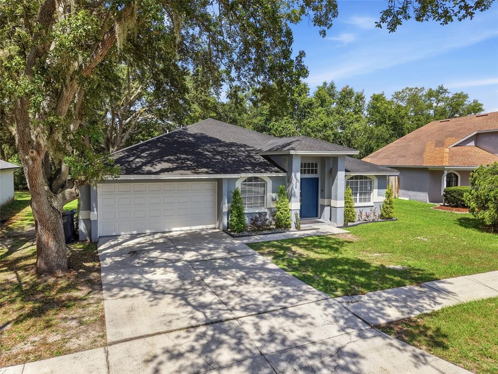 A single-story house with a gray exterior, a two-car garage, and a blue front door — 1328 GANGPLANK DRIVE, VALRICO, FL