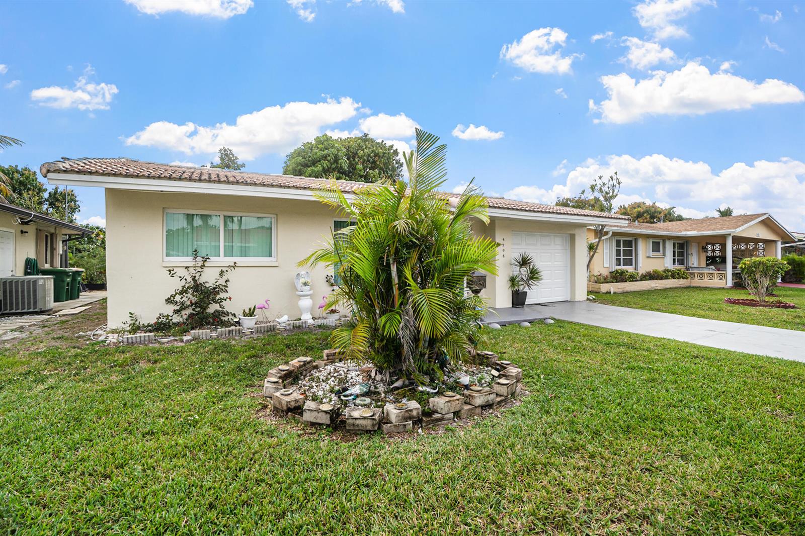 A single-story house with a palm tree in the front yard and a concrete driveway — 4708 NW 49th Drive, Tamarac FL 33319, TAMARAC, FL