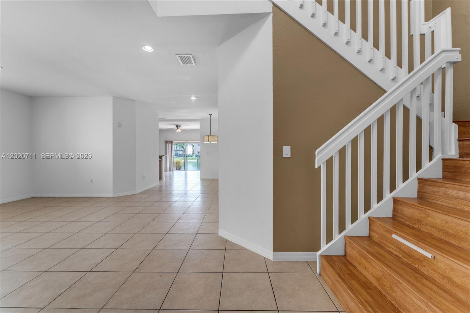 A tiled living area leads to a sliding glass door with a staircase on the right — 11318 NW 44th Ter, Doral FL 33178, DORAL, FL