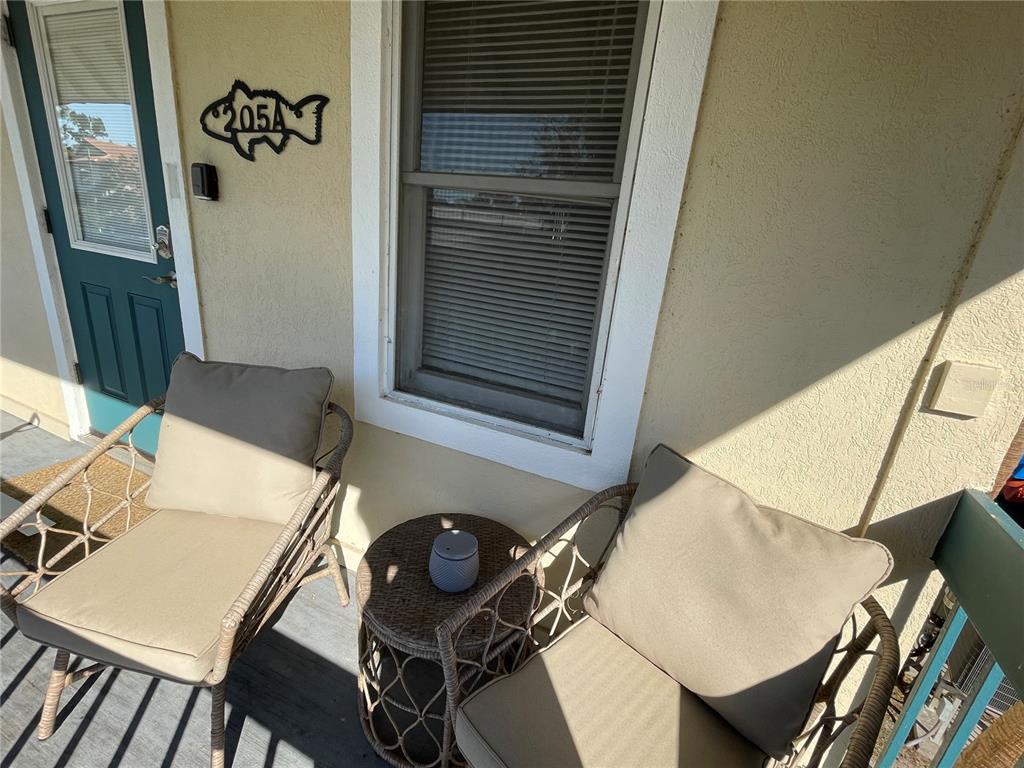 A patio features two wicker chairs with cushions and a small side table — 30 SE VALARE LANE UNIT 205A, CRYSTAL RIVER, FL