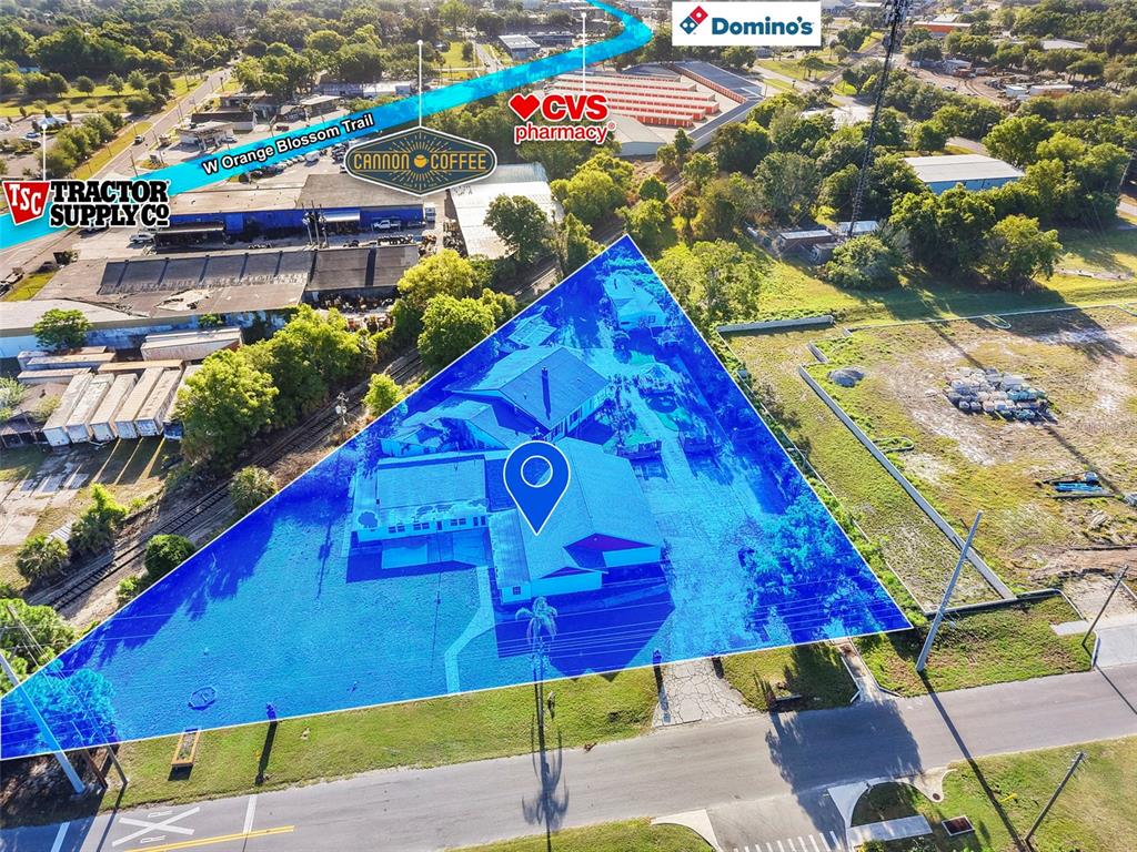 This aerial view shows a triangular property lot highlighted in blue with a building — 227 S HAWTHORNE AVENUE, APOPKA, FL