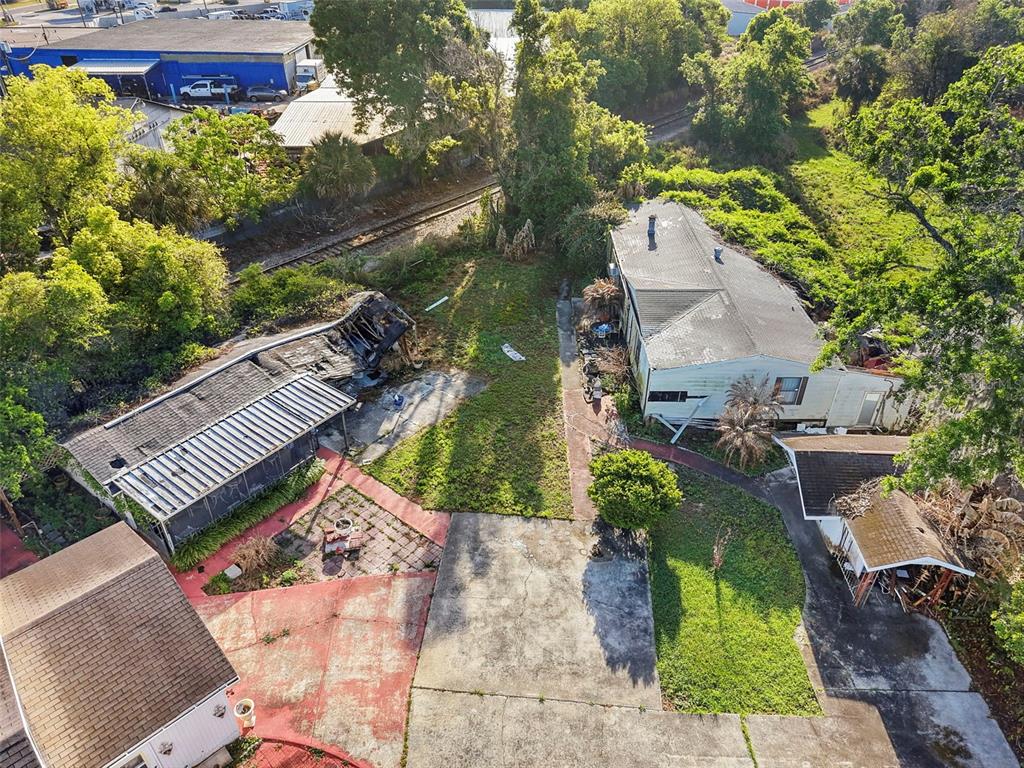 An aerial view shows a property with a fire-damaged structure and a separate house — 227 S HAWTHORNE AVENUE, APOPKA, FL